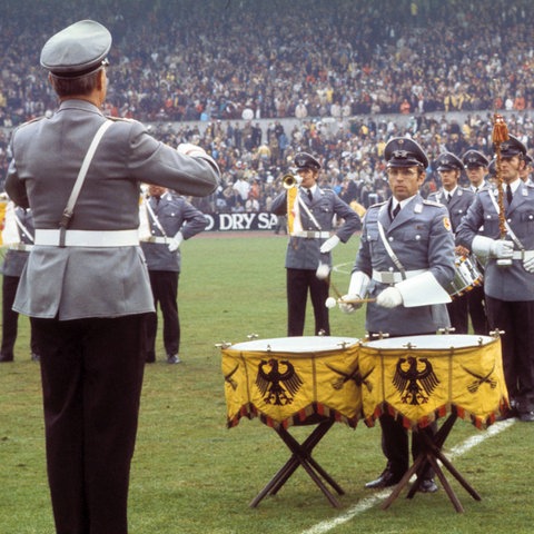 Ein Bundeswehr-Orchester spielt die Nationalhymne.