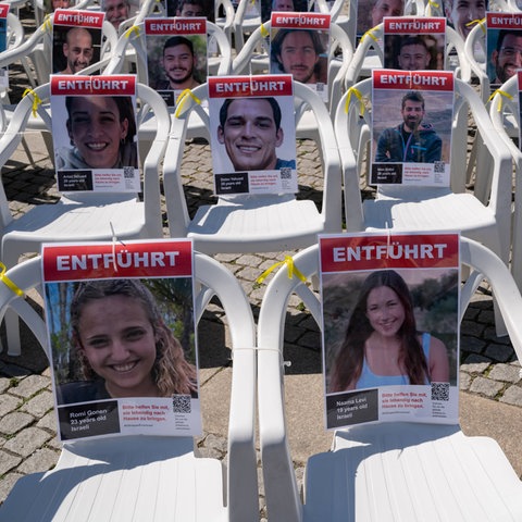 Die Porträts der entführten israelischen Geiseln sind an leeren Stühlen auf dem Bebelplatz in Berlin-Mitte angebracht.