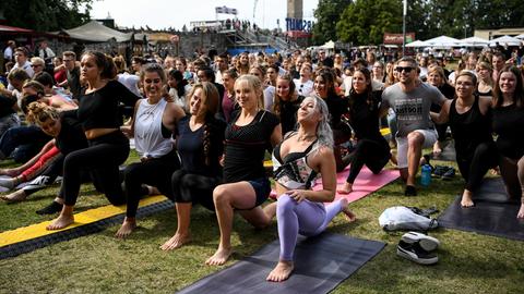 Besucher machen Yoga bei einem Festival in Berlin.