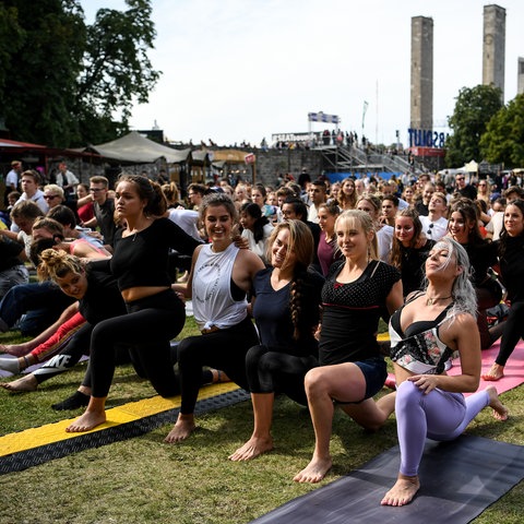 Besucher machen Yoga bei einem Festival in Berlin.