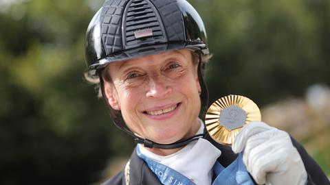 Isabell Werth jubelt bei den Olympischen Spielen in Paris über eine Goldmedaille.