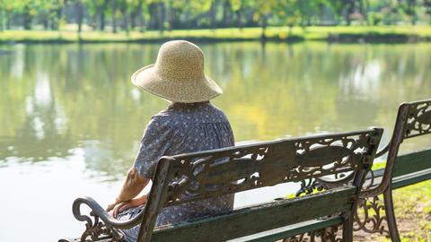 Einsame Frau auf Bank am See