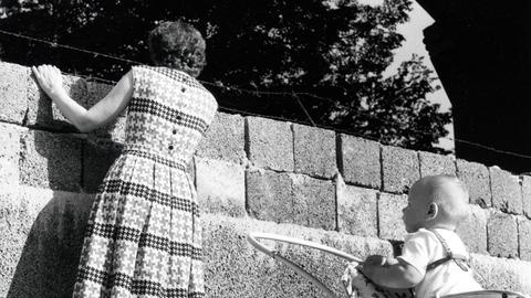 Eine junge Mutter schaut 1961 über die Mauer.