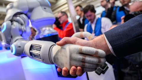 Ein Roboter gibt einem Mann die Hand