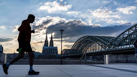 Jogger vor der Skyline von Köln