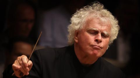 Simon Rattle dirigiert.