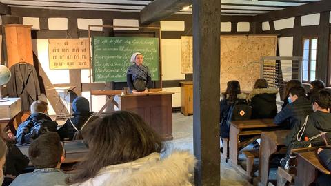 Schülerinnen und Schüler in einem alten Schulraum im Hessenpark